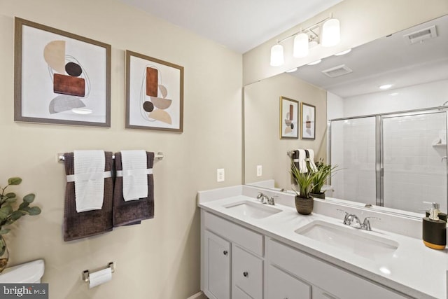 bathroom with vanity, toilet, and a shower with shower door