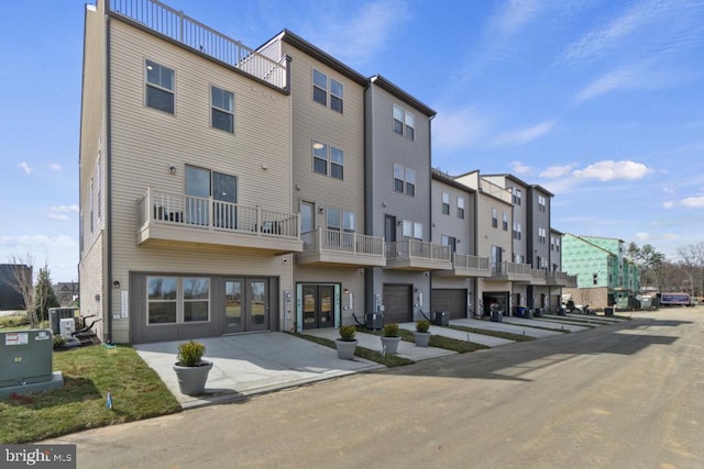 view of building exterior with central AC and a garage