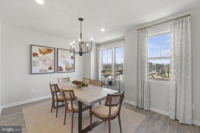 dining space featuring hardwood / wood-style floors and an inviting chandelier