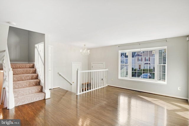 unfurnished room featuring a chandelier and hardwood / wood-style flooring