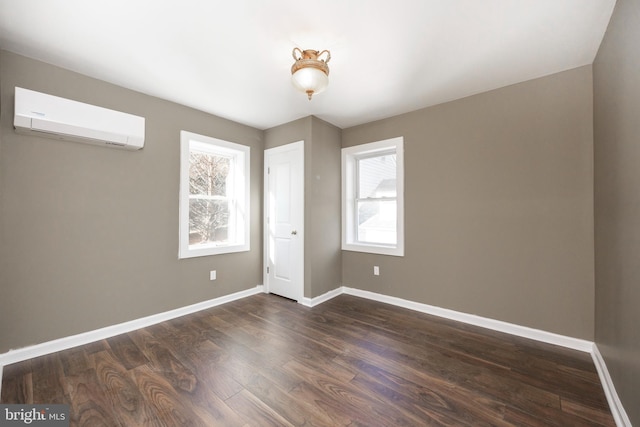 unfurnished bedroom with dark hardwood / wood-style flooring and a wall mounted AC