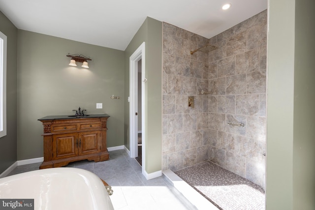 bathroom with tile patterned flooring, vanity, and tiled shower