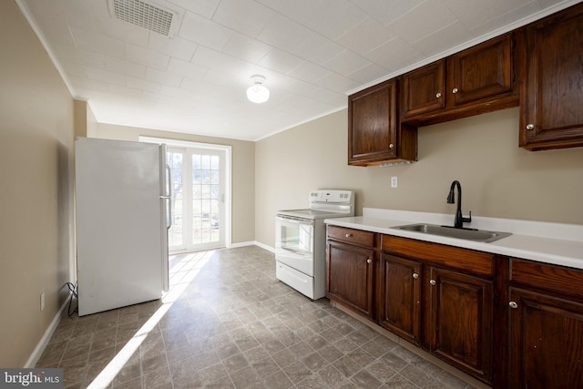 kitchen with white appliances, french doors, sink, ornamental molding, and dark brown cabinetry