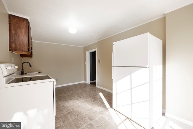 clothes washing area featuring cabinets, washer / dryer, crown molding, and sink