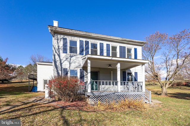 view of front of house featuring ceiling fan, a front lawn, and covered porch