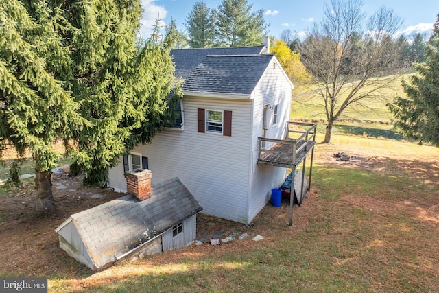 view of home's exterior with a balcony and a yard