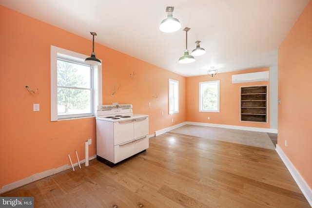 kitchen with white electric range oven, light hardwood / wood-style floors, plenty of natural light, and hanging light fixtures