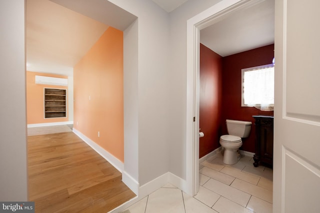 bathroom with toilet, wood-type flooring, and an AC wall unit