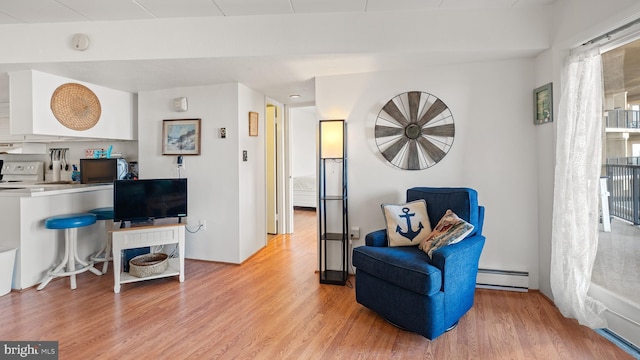 sitting room featuring light hardwood / wood-style floors and a baseboard heating unit