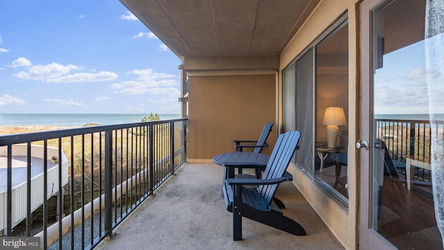 balcony featuring a water view and a view of the beach