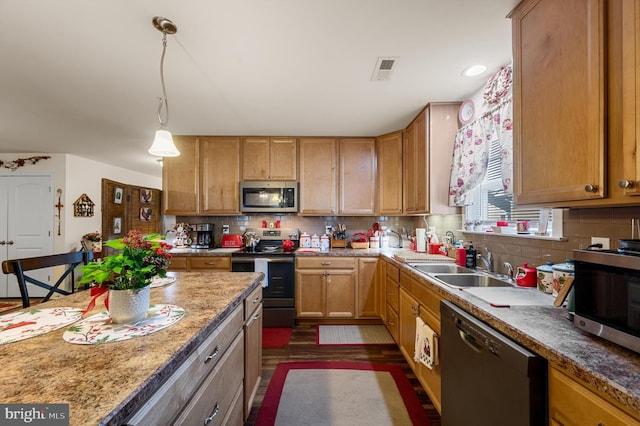 kitchen featuring decorative light fixtures, stainless steel appliances, tasteful backsplash, and sink