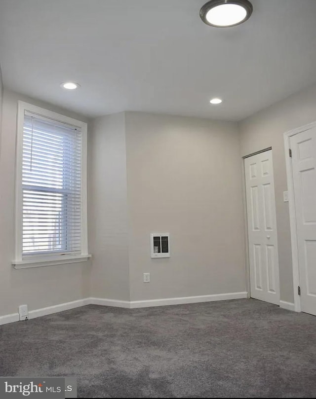 empty room featuring dark colored carpet