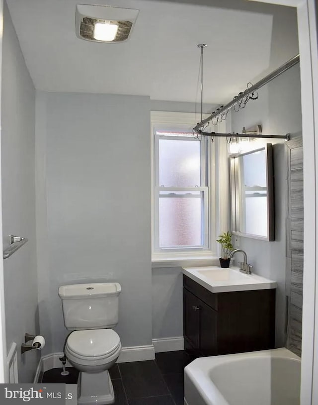 bathroom featuring tile patterned floors, vanity, toilet, and a tub to relax in