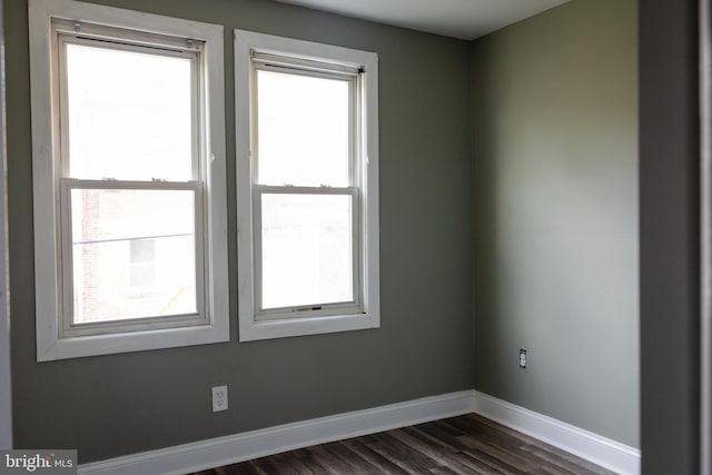 empty room featuring dark hardwood / wood-style flooring and plenty of natural light