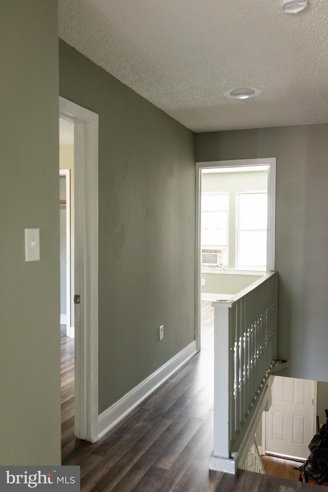 interior space featuring a textured ceiling and dark wood-type flooring