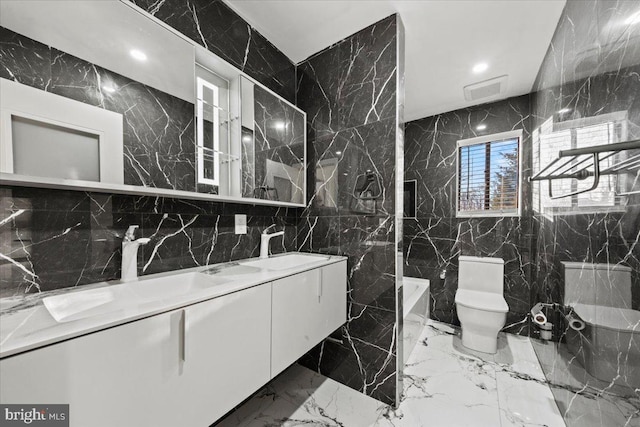 bathroom featuring vanity, tile walls, and toilet