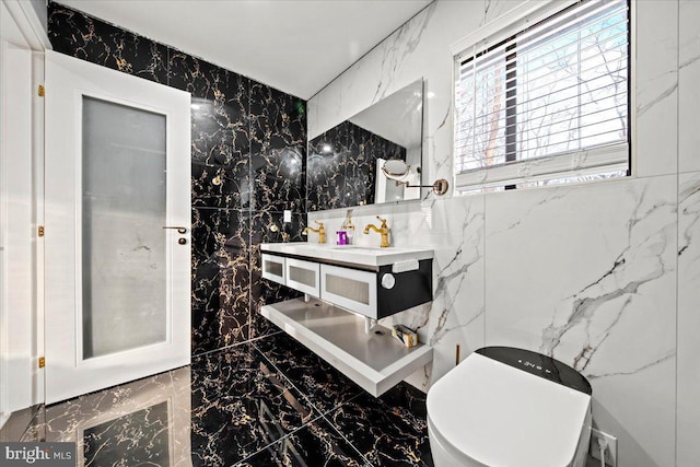 bathroom with vanity, toilet, and tile walls