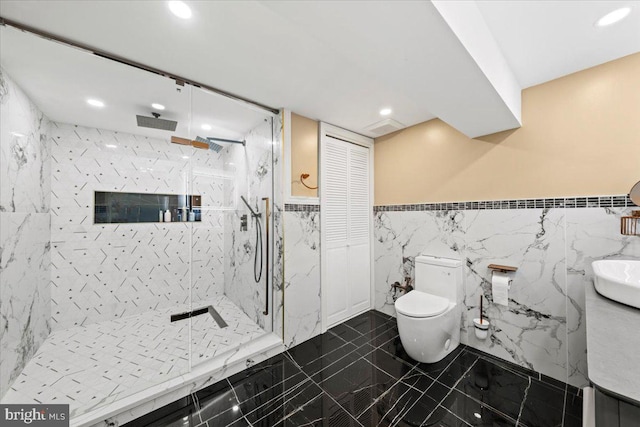 bathroom featuring tiled shower, toilet, and tile walls