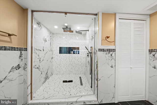 bathroom with tiled shower and tile walls