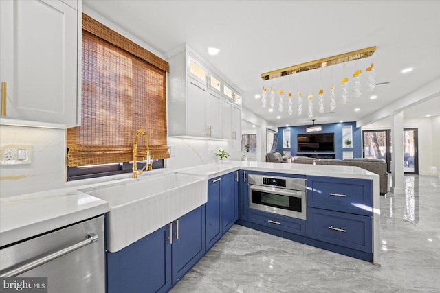 kitchen with white cabinetry, stainless steel appliances, tasteful backsplash, kitchen peninsula, and decorative light fixtures