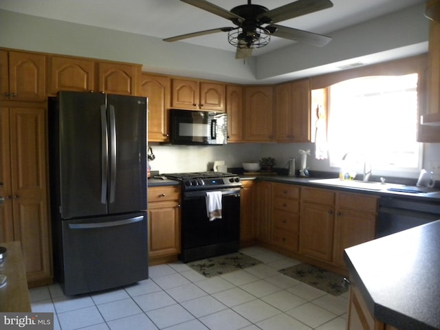 kitchen featuring light tile patterned flooring, sink, ceiling fan, and black appliances