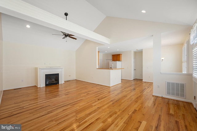 unfurnished living room featuring beam ceiling, ceiling fan, high vaulted ceiling, and light hardwood / wood-style floors