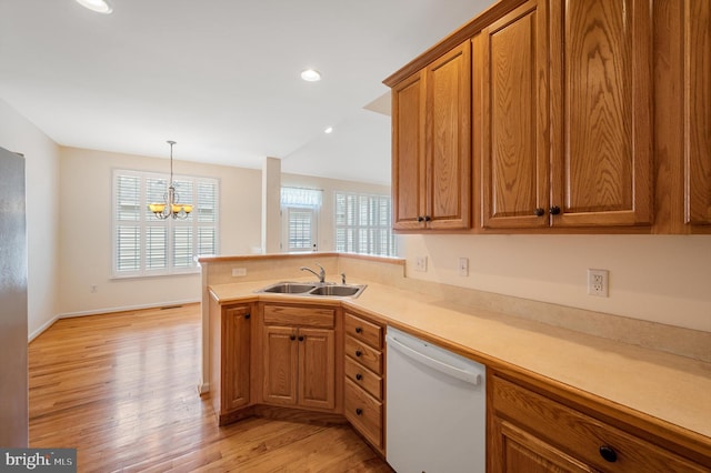 kitchen with dishwasher, sink, light hardwood / wood-style flooring, kitchen peninsula, and a chandelier