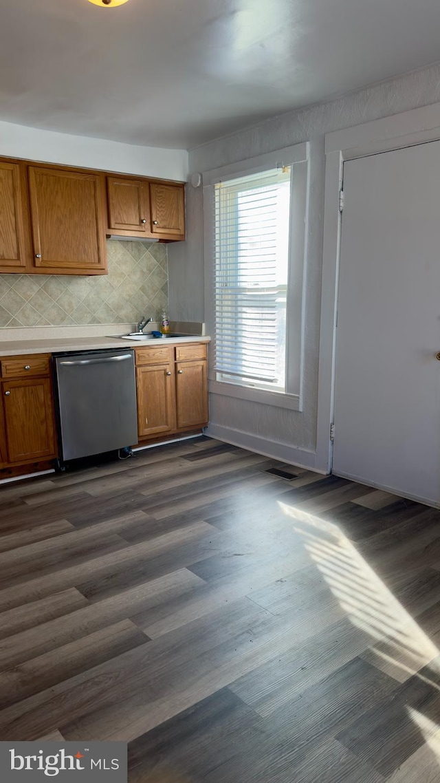 kitchen with tasteful backsplash, dark hardwood / wood-style flooring, and stainless steel dishwasher