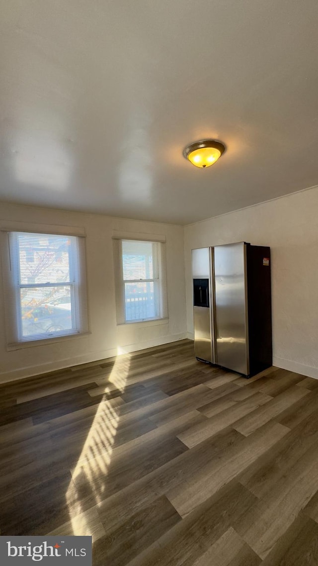 interior space with stainless steel fridge and dark wood-type flooring