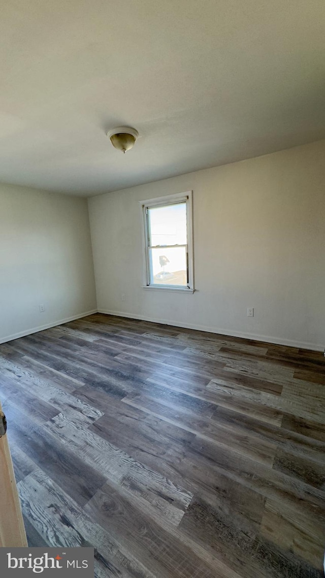 empty room with dark hardwood / wood-style flooring