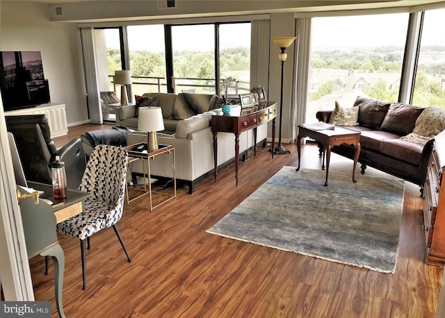 living room featuring wood finished floors, visible vents, and baseboards