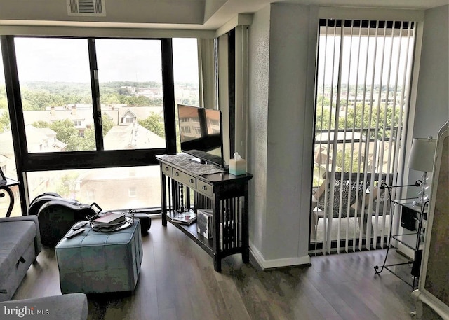 sitting room featuring visible vents, plenty of natural light, and wood finished floors