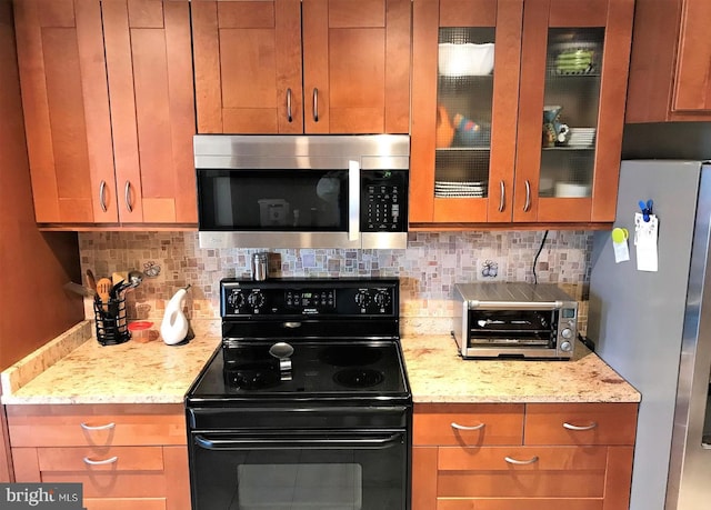 kitchen with stainless steel appliances, light stone countertops, decorative backsplash, and a toaster