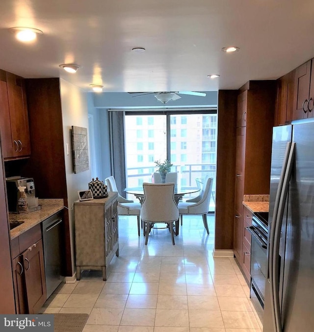 kitchen featuring light tile patterned floors, light stone countertops, and stainless steel appliances