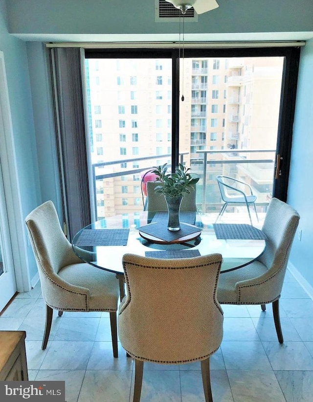 tiled dining room featuring baseboards