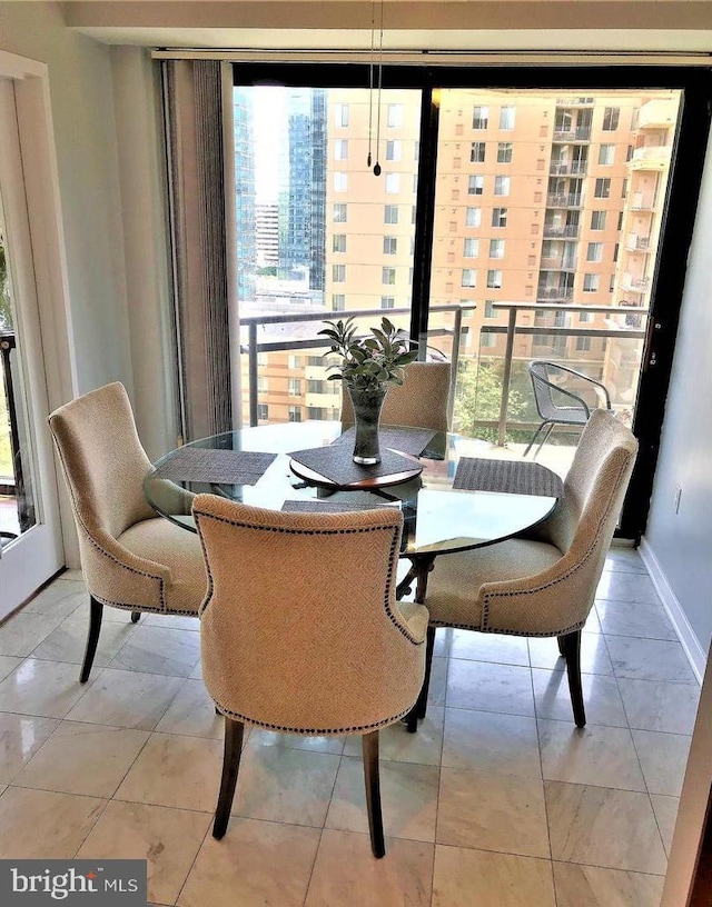 dining area with plenty of natural light, baseboards, and light tile patterned floors