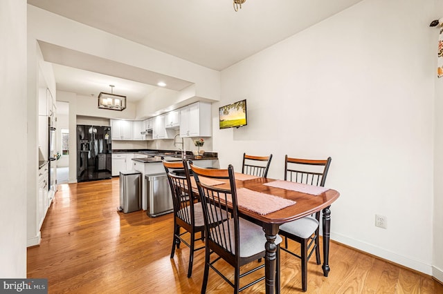 dining space with a chandelier and light hardwood / wood-style flooring