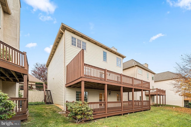 rear view of house with a deck and a lawn