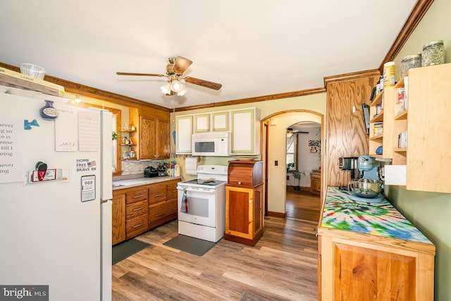 kitchen with backsplash, wood-type flooring, white appliances, and crown molding