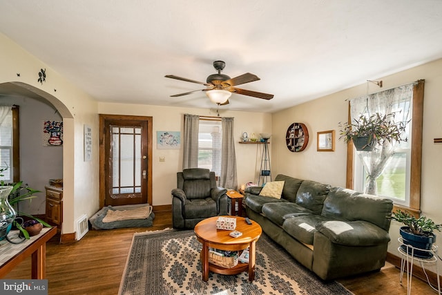 living room with ceiling fan and dark wood-type flooring