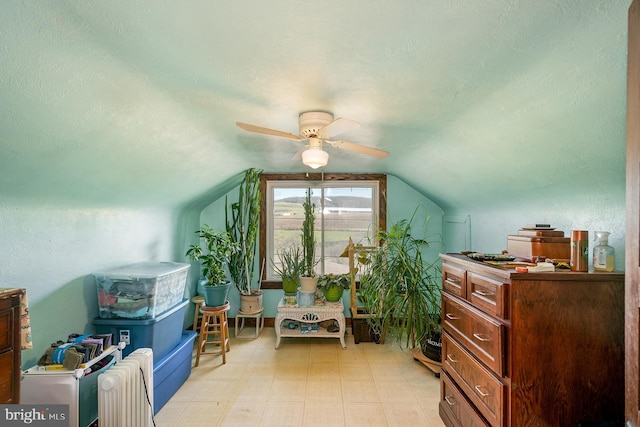 additional living space with a textured ceiling, vaulted ceiling, and ceiling fan