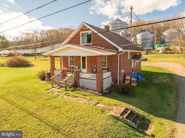 exterior space with covered porch and a front yard