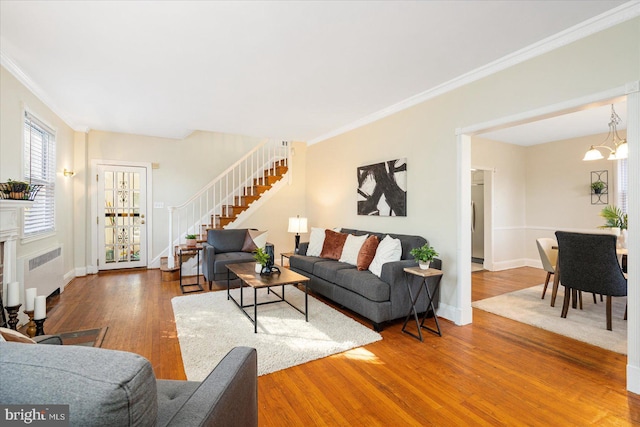 841 E Belvedere Ave E, Baltimore, MD 21212 - living room with radiator, wood finished floors, stairs, a chandelier, and crown molding