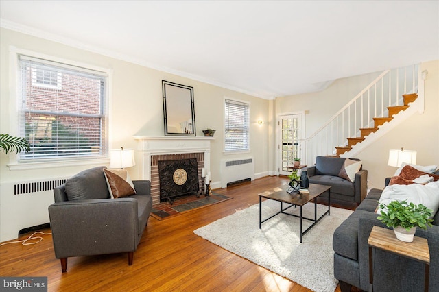 841 E Belvedere Ave E, Baltimore, MD 21212 - living room featuring radiator, stairs, wood finished floors, plenty of natural light, and ornamental molding