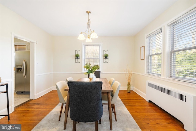 841 E Belvedere Ave E, Baltimore, MD 21212 - dining space with radiator, light wood-style floors, a chandelier, and baseboards