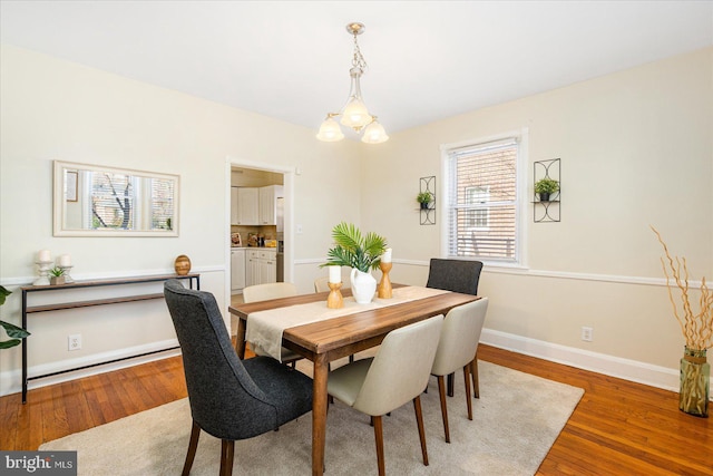 841 E Belvedere Ave E, Baltimore, MD 21212 - dining space featuring wood finished floors, baseboards, and a chandelier