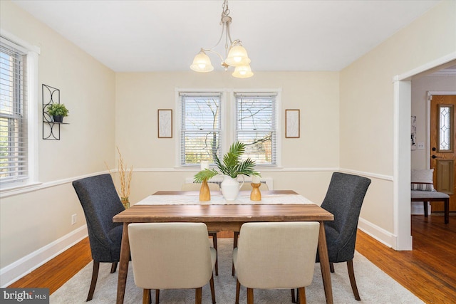 841 E Belvedere Ave E, Baltimore, MD 21212 - dining room with a chandelier, wood finished floors, and baseboards
