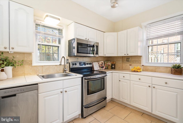 841 E Belvedere Ave E, Baltimore, MD 21212 - kitchen featuring appliances with stainless steel finishes, a sink, healthy amount of natural light, and white cabinets