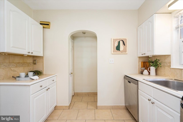 841 E Belvedere Ave E, Baltimore, MD 21212 - kitchen with stainless steel dishwasher, arched walkways, white cabinets, tasteful backsplash, and light countertops