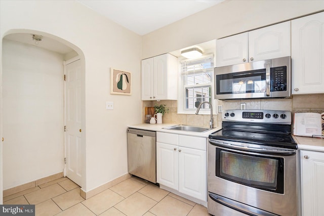 841 E Belvedere Ave E, Baltimore, MD 21212 - kitchen featuring appliances with stainless steel finishes, a sink, tasteful backsplash, arched walkways, and light countertops